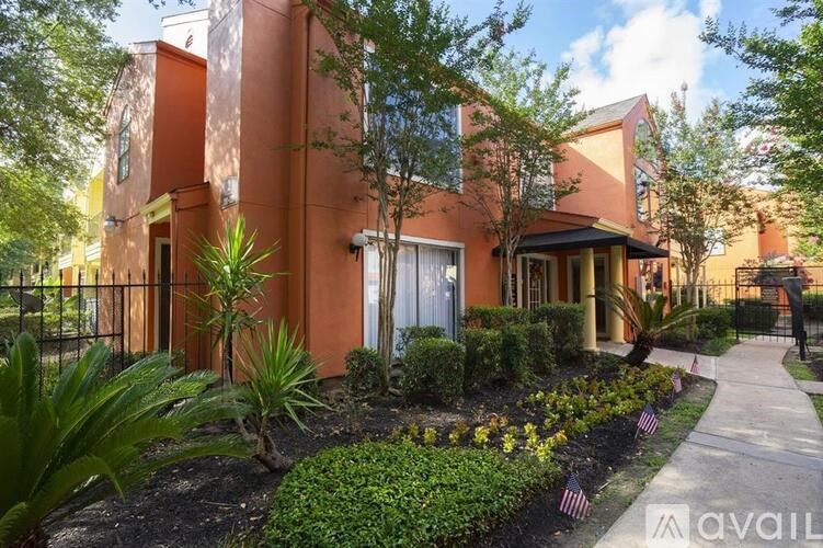 A house with a red exterior and a well-maintained garden in front.