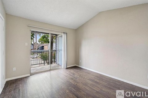 Empty room with a sliding glass door leading to a balcony.