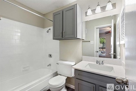 A bathroom with a white toilet, sink, and bathtub.
