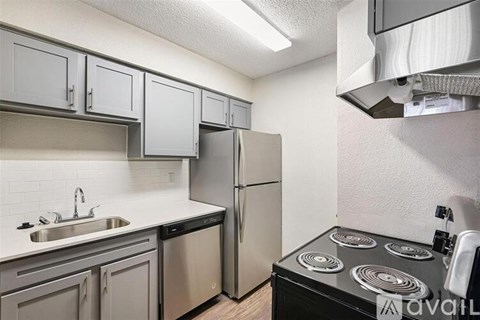 A kitchen with a stove top oven and a sink.