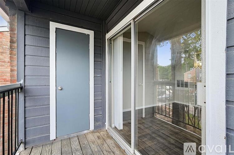 A balcony with a blue door and glass windows.