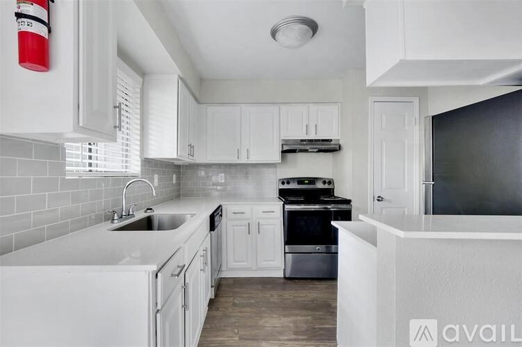 A kitchen with white cabinets and a black countertop.