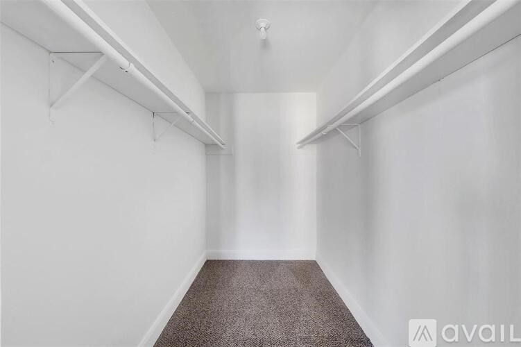 A long, narrow hallway with white walls and a carpeted floor.
