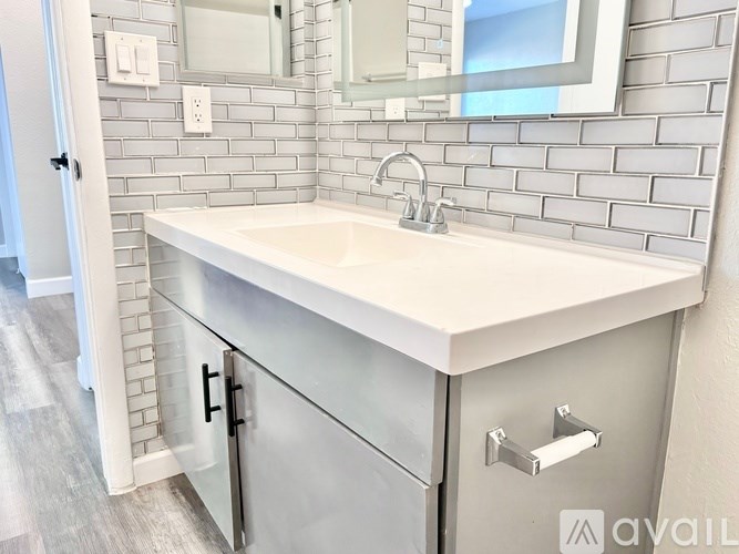 A white sink is on a counter under a mirror.