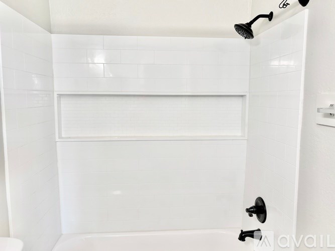 A white bathroom with a shower and a toilet.