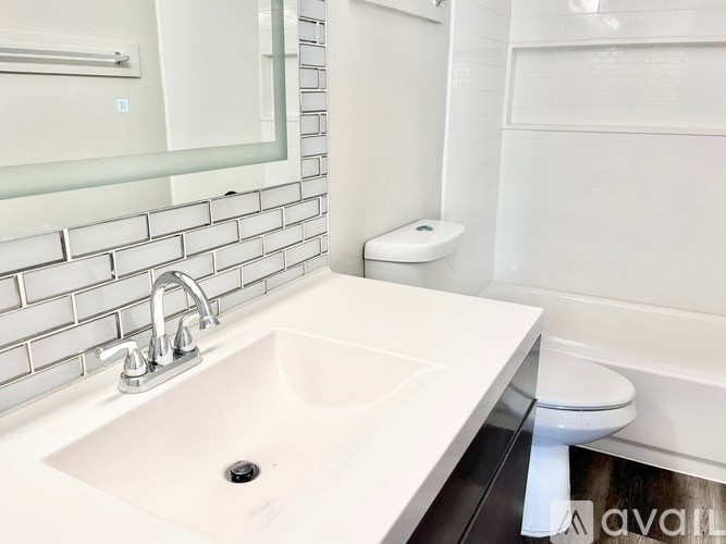 A white sink with a chrome faucet in a modern bathroom.