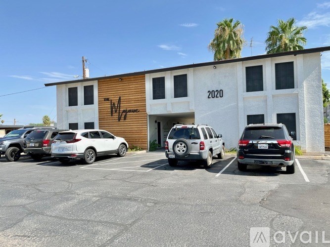 A parking lot with several cars and a building with the year 2020 on it.