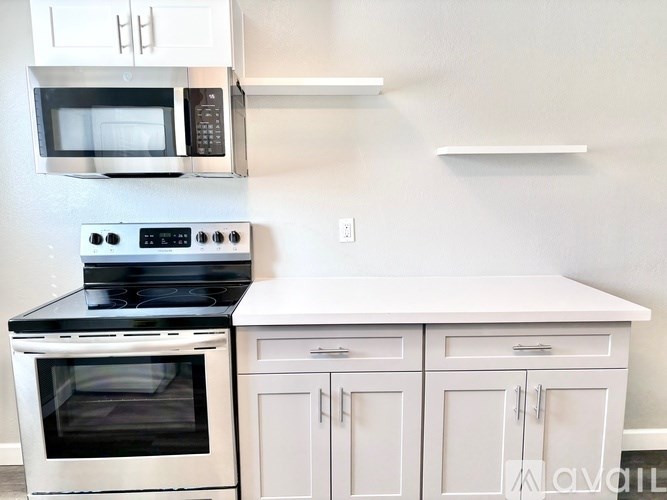 A kitchen with white cabinets and a black stove top oven.