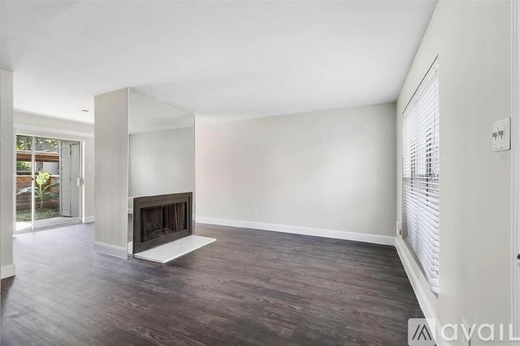 A spacious living room with a fireplace and wooden flooring.