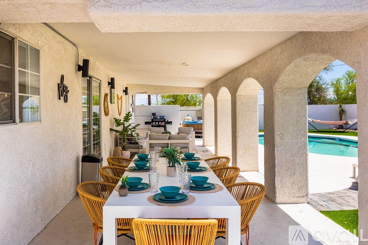 A table set for a meal with a pool in the background.