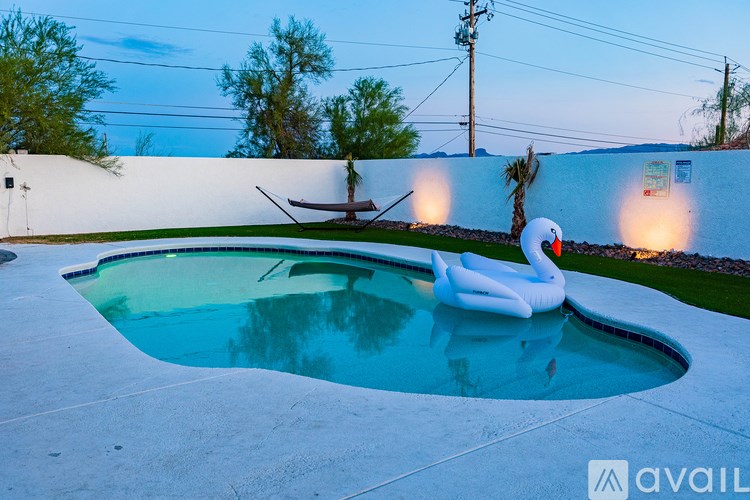 A pool with a white inflatable flamingo in the middle of it.