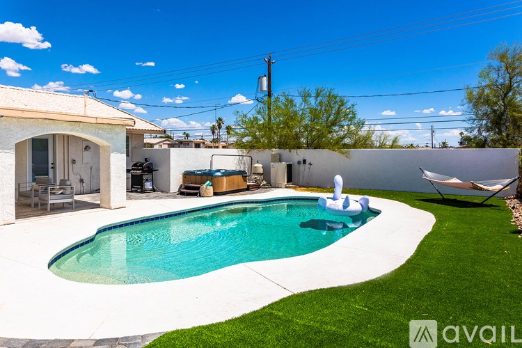 A pool with a white fence and a hammock.