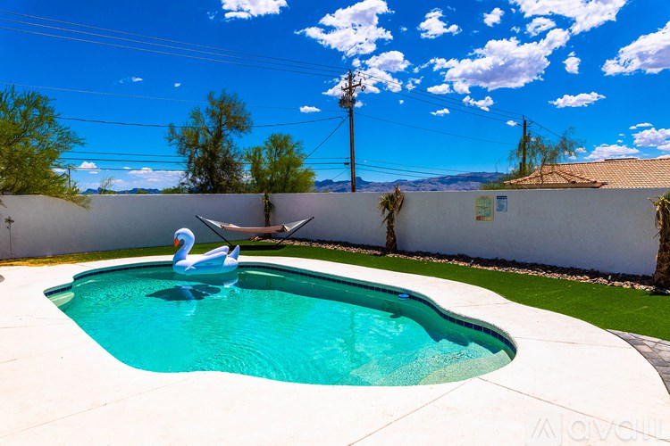 A swimming pool with a blue water and a white wall.