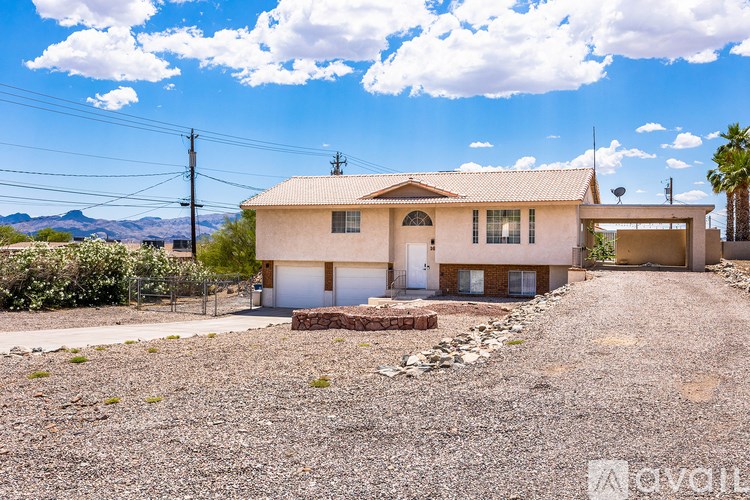 A house with a gravel driveway in front of it.
