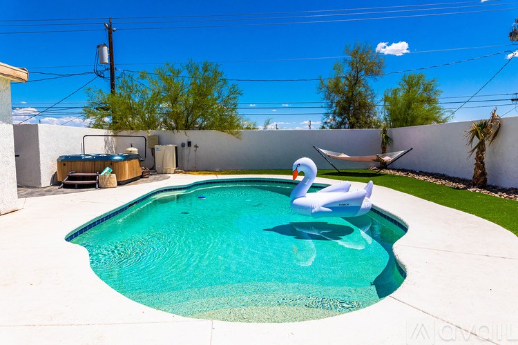 A white swan float in a blue pool.