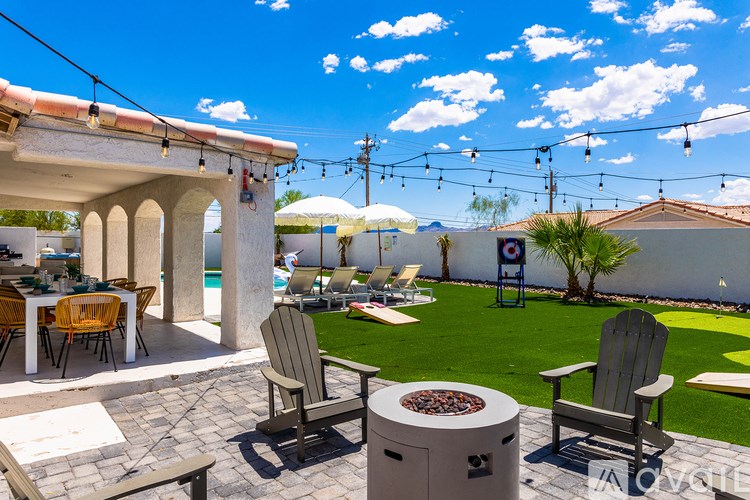 A patio with chairs and a fire pit.