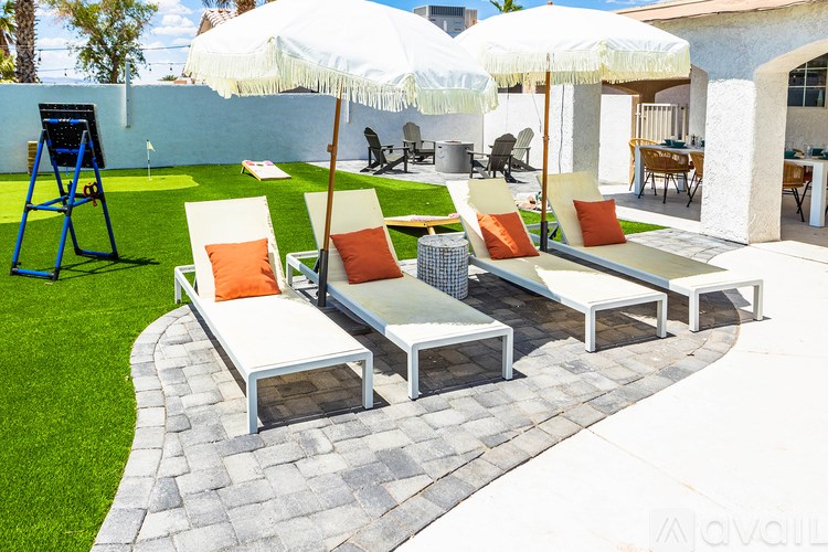 A patio with white umbrellas and orange cushions.