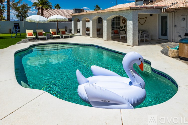 A white inflatable duck floats in a pool.