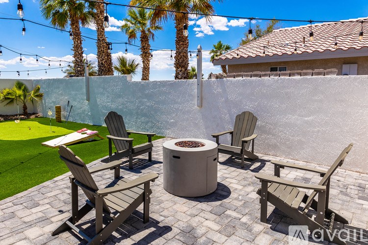 A patio with a fire pit and chairs.