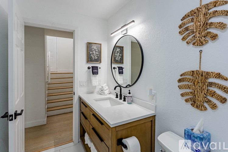 A bathroom with a sink, mirror, and towel rack.