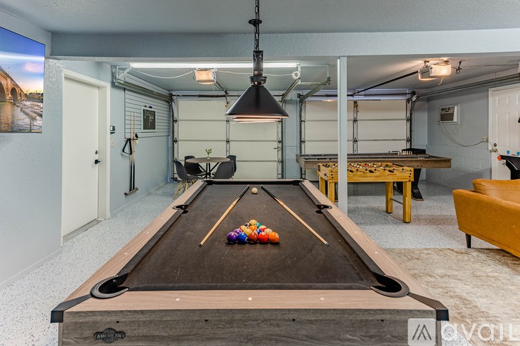 A pool table in a room with a light hanging from the ceiling.