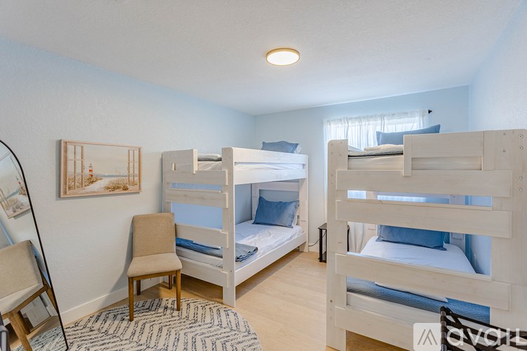 A room with two bunk beds and a chair.