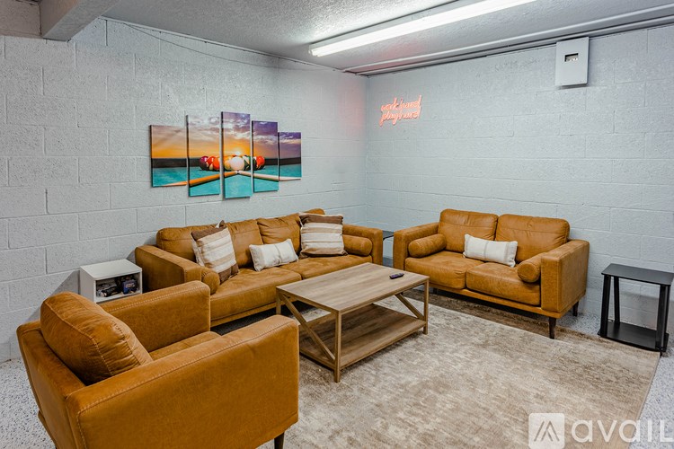 A living room with a brown sofa, two armchairs, and a coffee table.