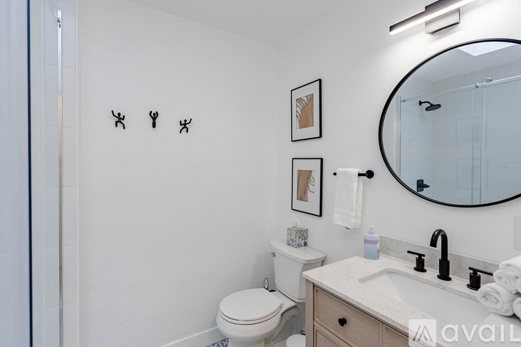 A bathroom with a toilet, sink, and mirror.