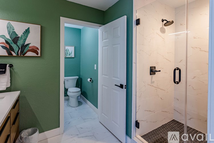 A bathroom with a green wall and a white door.