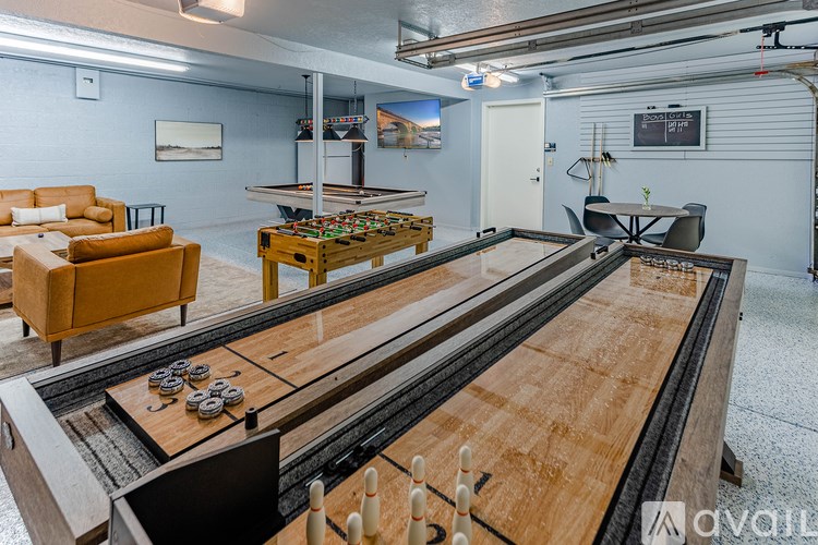 A room with a shiny wooden table and a couch.
