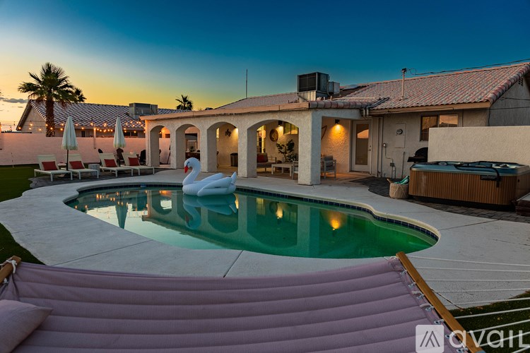 A pool with a slide and a hot tub in the middle of a backyard.