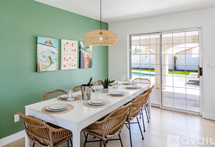 A dining room with a white table and chairs.