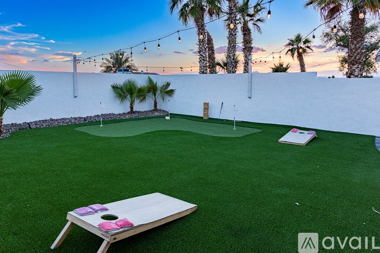 A backyard with a putting green and palm trees.