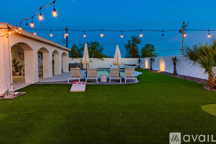 A patio area with white furniture and string lights.