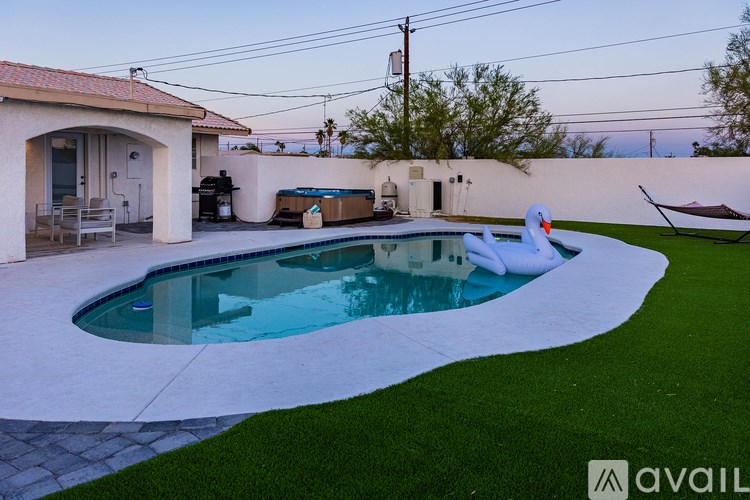 A swimming pool with a slide in the middle of a backyard.