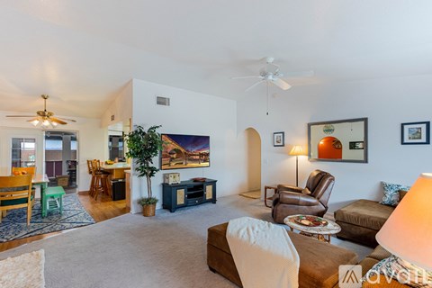 A living room with a white couch and a painting on the wall.