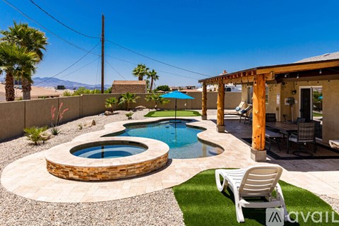 A wooden pole stands next to a pool with a stone border.