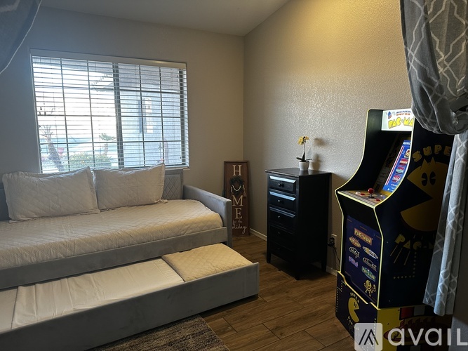 A room with a couch, a small table, and a gaming console.