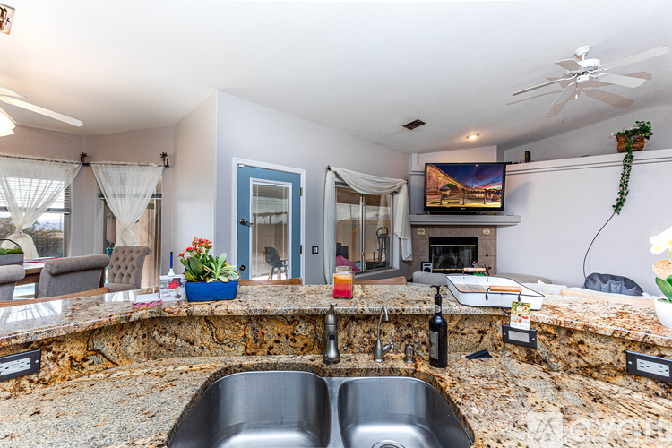 A kitchen with a stone counter top and a sink.