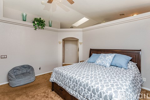A bedroom with a large bed and a grey dog bed.