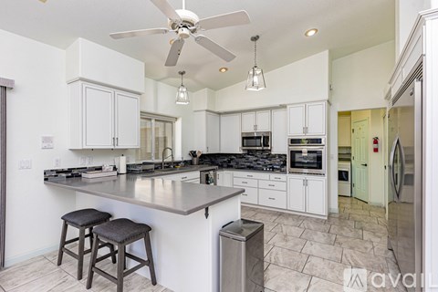 A modern kitchen with white cabinets and a large island.