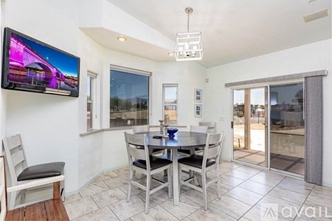 A modern dining room with a television mounted on the wall.