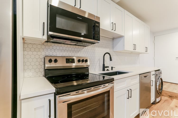 A kitchen with a black stove top oven and white cabinets.