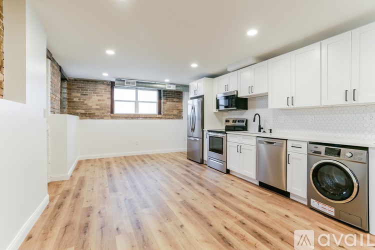 A kitchen with wooden floors and white cabinets is available.