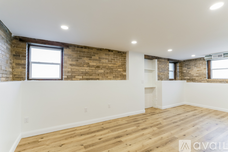 A room with wooden floors and a brick wall.