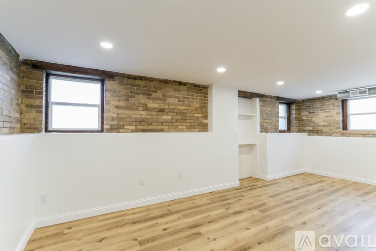 A room with wooden floors and a brick wall.