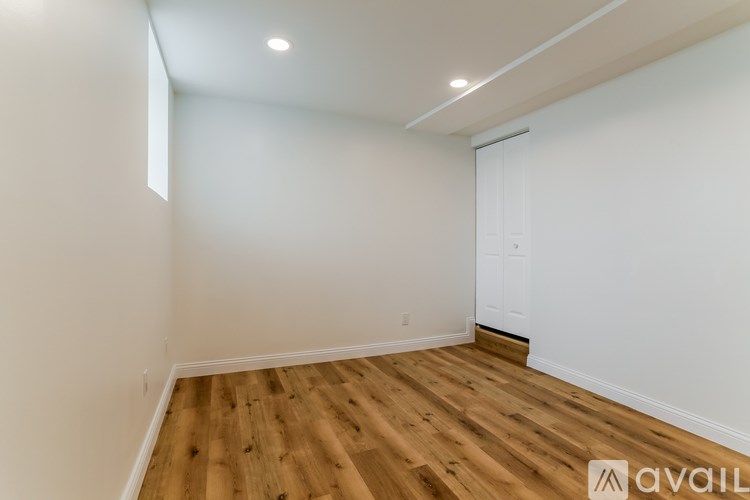 A room with wooden flooring and white walls.