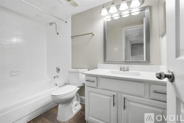 A white bathroom with a toilet, sink, and mirror.