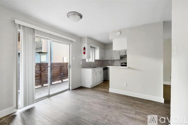 A kitchen with white cabinets and a wooden floor.