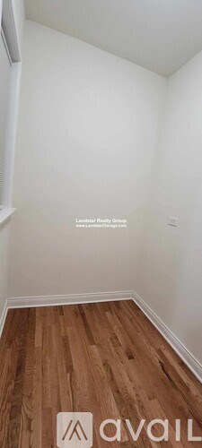 A room with wooden flooring and white walls.